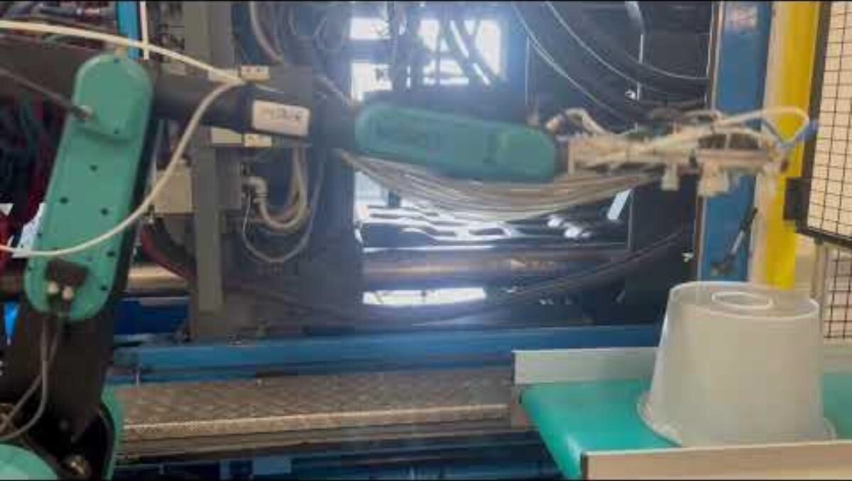 Robot en action à la sortie d'une presse à injecter, cellule Mabin